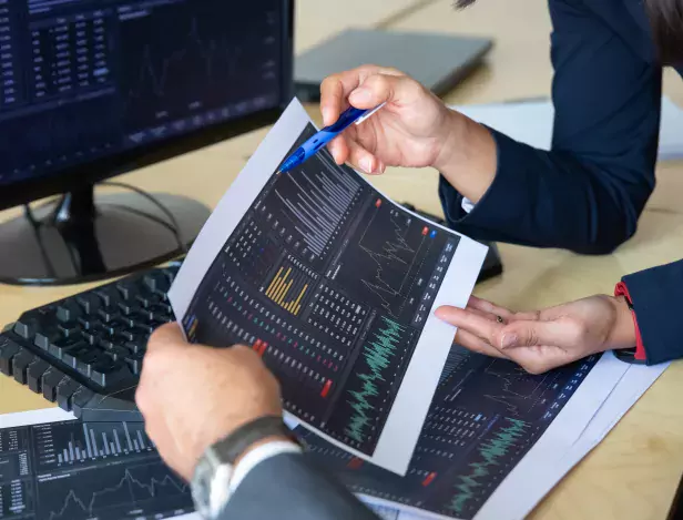 brokers-discussing-trading-strategy-holding-papers-with-financial-data-pointing-pen-at-charts-cropped-shot-broker-job-or-stock-market-exchange-concept