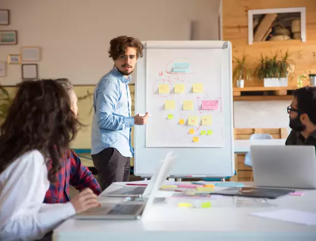 startup-leader-drawing-flowchart-on-board-and-discussing-project